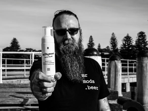 bearded man holding a beard wash