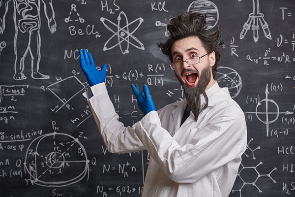 bearded scientist explaining beard growth on a black board