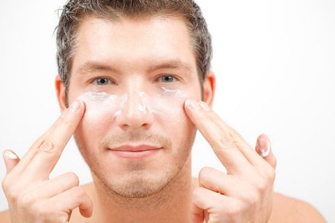man rubbing moisturiser on face