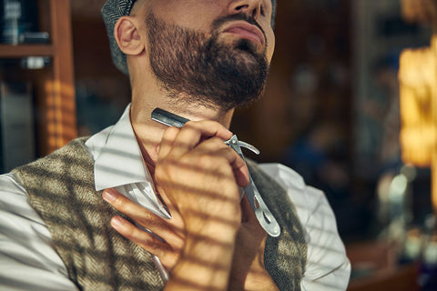 man shaving the neckline of his beard