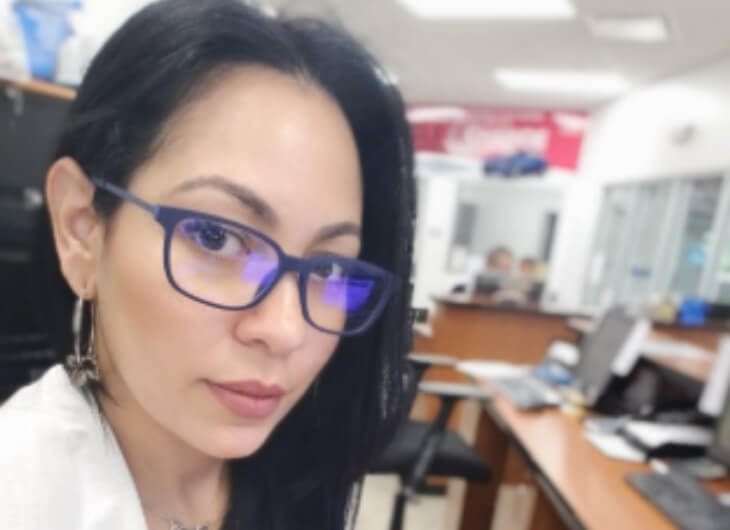 Claritza wears her Umizato blue light glasses while using computer