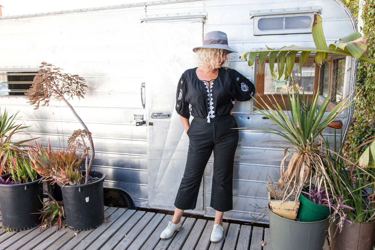 Leila Ligougne  muse Christine Wolheim wearing the Lola blouse in front of an airstream