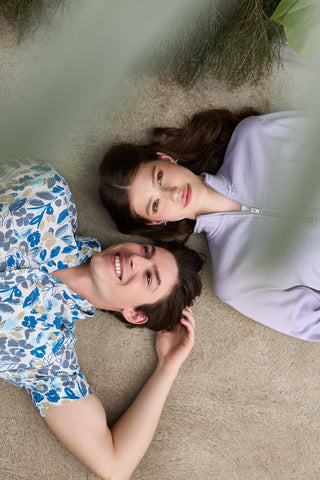 photo from above showing a man and woman lying on their backs looking up at the sky