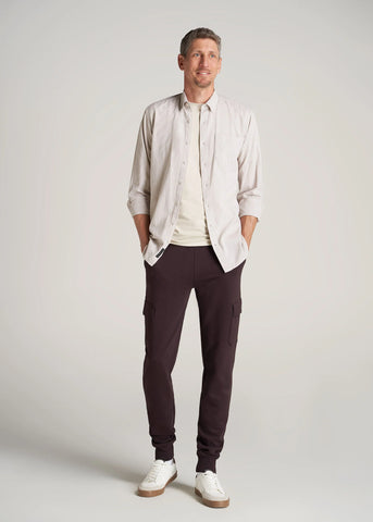 Man standing with hands in pockets wearing linen button shirt and dark pants
