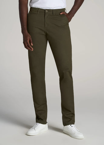 Closeup of man wearing tall tapered chino pants in camo green color with white tee