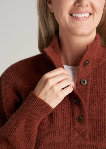 Closeup of tall woman wearing mock-neck sweater with buttons in deep copper color