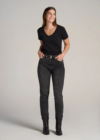 Woman standing wearing black v-neck tee with dark skinny jeans