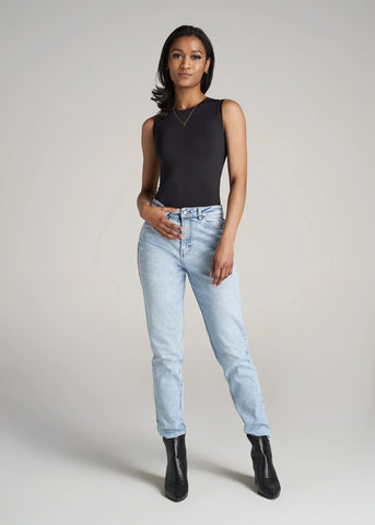 Woman standing wearing light wash jeans and black sleeveless bodysuit
