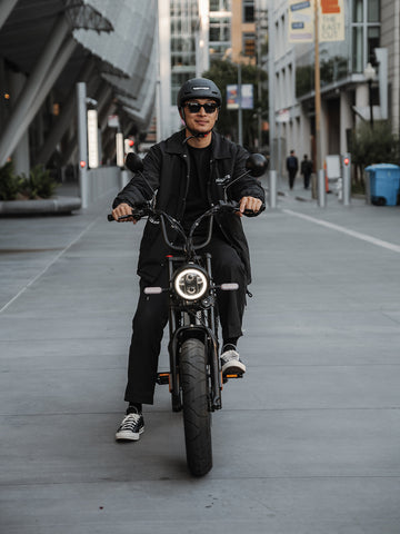 Young man riding black Juiced HyperScrambler e-bike