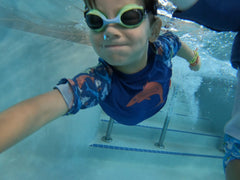 beau swimming underwater at Great Wolf Lodge wearing the BBLittles rash guard