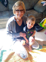 toddler boy sitting with his speech therapist