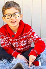 little boy with glasses smiling wearing his holiday sweater