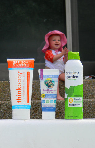 Sunscreen bottles with a baby in the background