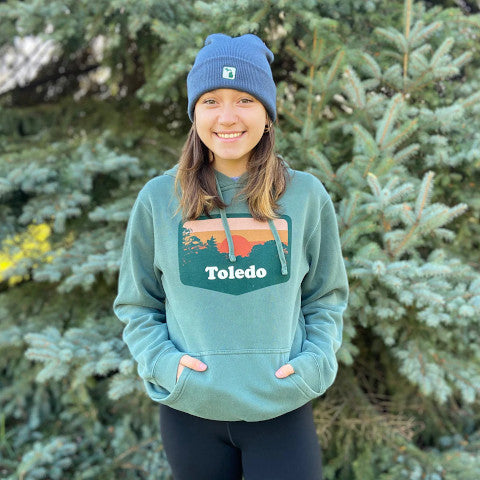 lady in an embroidered beanie and printed hoodie