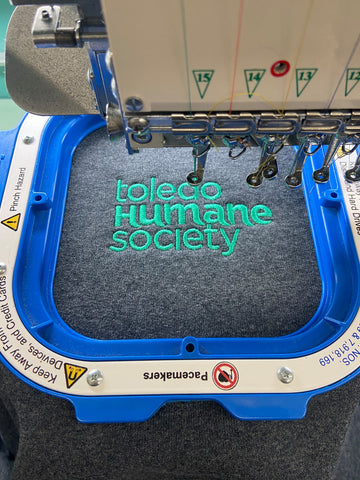 toledo humane society sweatshirt on an embroidery machine