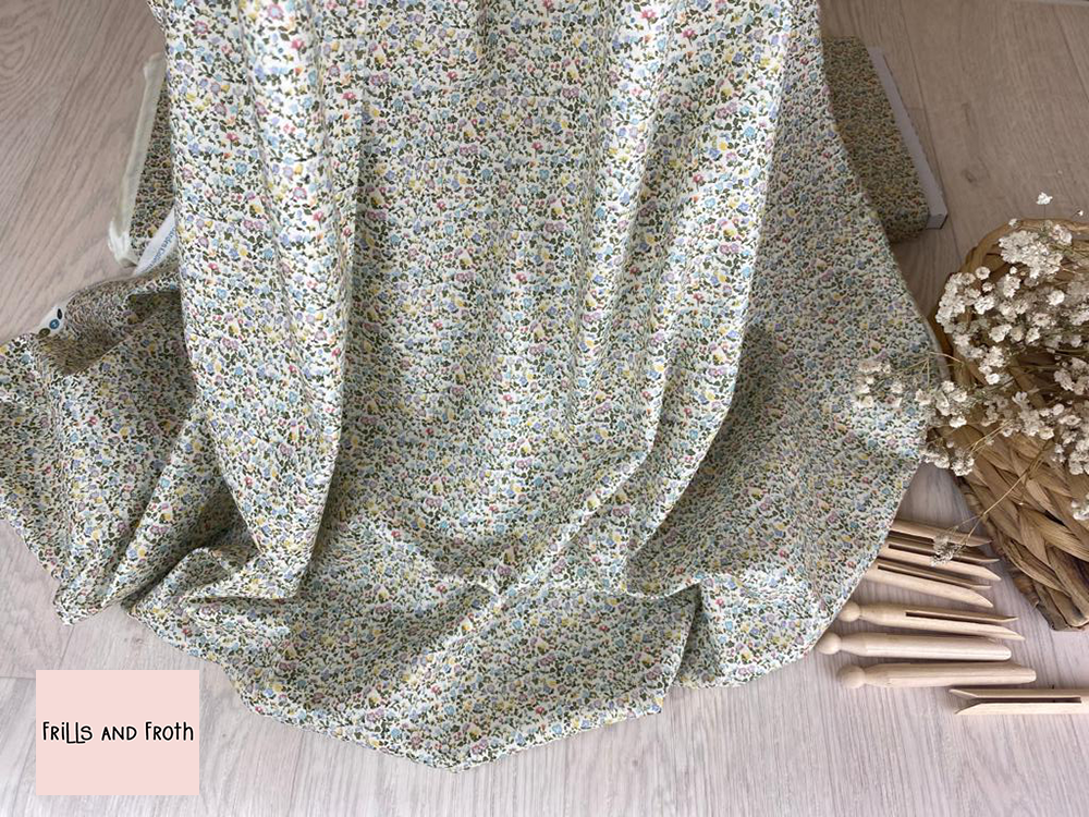 Picture showing drape of this Liberty Fabric along with wooden pegs and a basket of flowers. Liberty fabric 'Newland Large' quilting fabric Liberty 'Newland Large' fabric from the 'English Garden' collection features a multi coloured floral design.