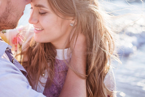 Couple at beach embracing to a kiss with ocean in the background