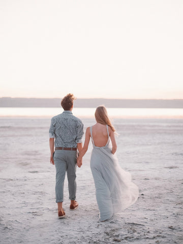 twin flame couple walking hand in hand on the beach on their wedding day
