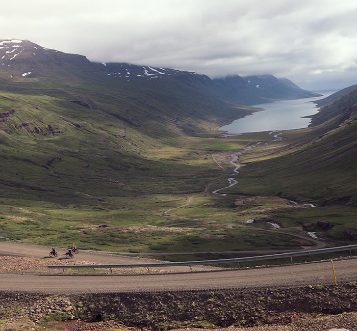 Image of valley with cyclers riding down the road and account addresses text