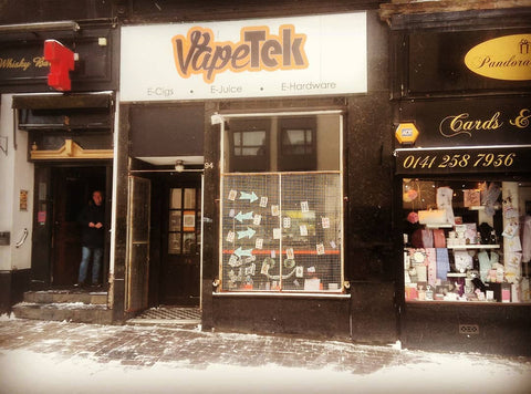 View of the outside of the Vapetek shop in mid winter. Snow is on the ground and the window shows a seasonal display.
