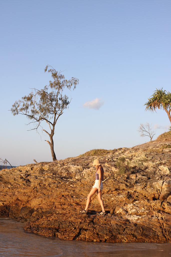 Woman walking along a rocky coast