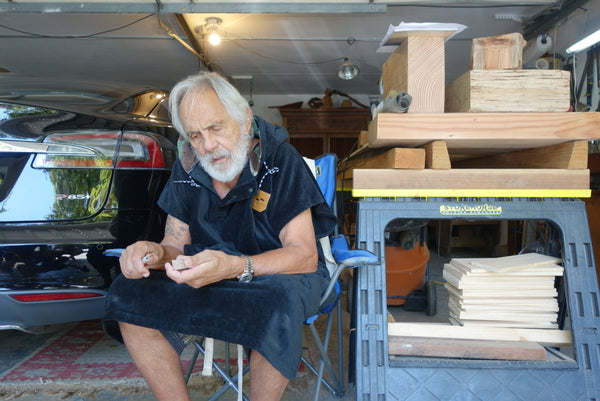 Tommy Chong hanging out in a car garage while wearing a sustainable changing poncho