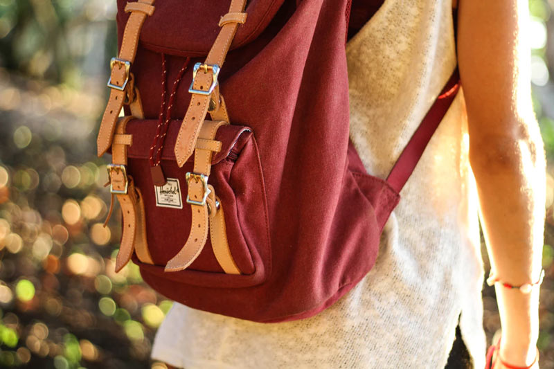 A girl wearing a dark-red backpack.