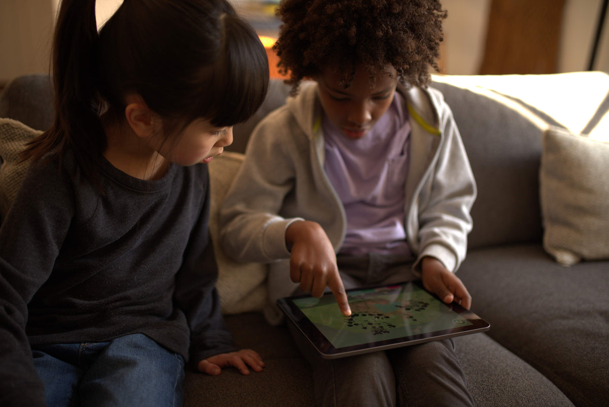 Two girls playing a game on an iPad