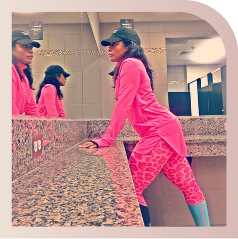 A customer posing while wearing a pink Spark Half-Zip by Veil Garments, a modest activewear sweatshirt.