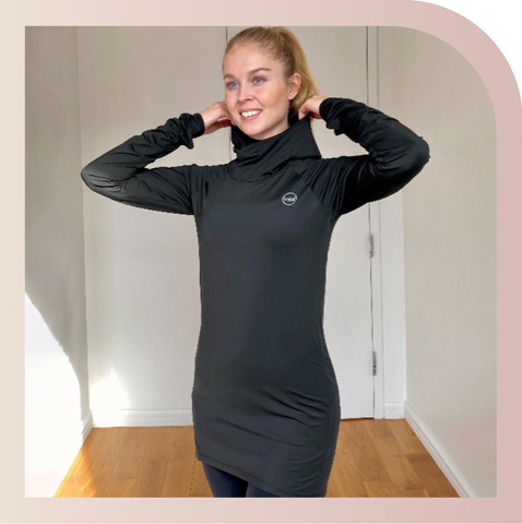 A customer posing while wearing a black Halo Running hoodie by Veil Garments, a modest activewear sweatshirt.