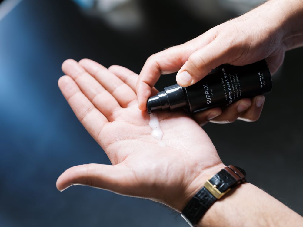 man putting supply activating beard serum into his hand