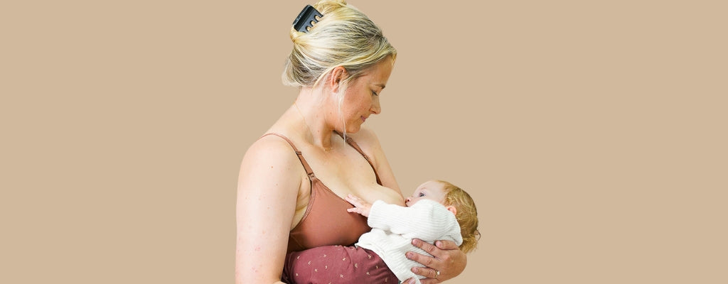mother breastfeeding baby in summer