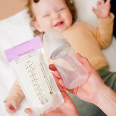 baby with baby bottle and breast milk storge bags