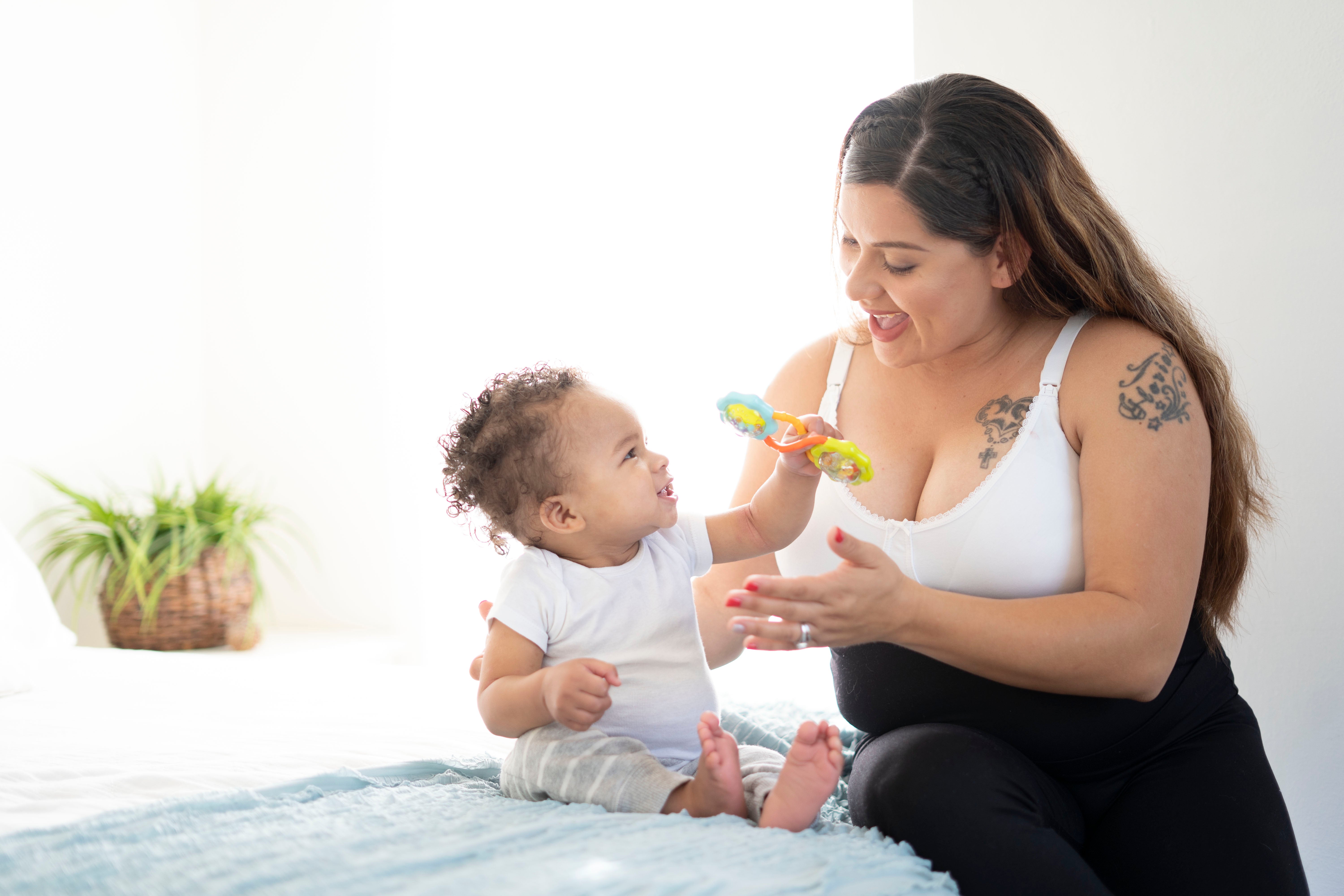 mother wearing maternity wear playing with baby