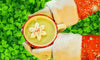 Lucky Elf Green Matcha Hoyt Chocolate being held by Santa over a table of shamrocks - St. Patrick's Day Christmas Holiday Recipe