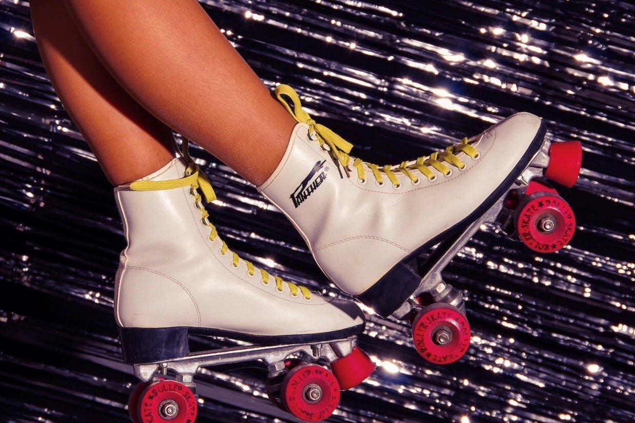 Womens Legs with Roller Skates in front of shiny retro disco backdrop