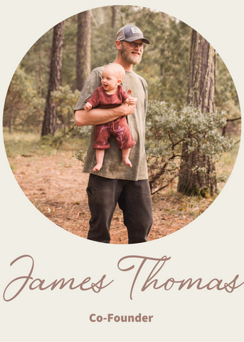 Man walking in a forest holding a little baby girl