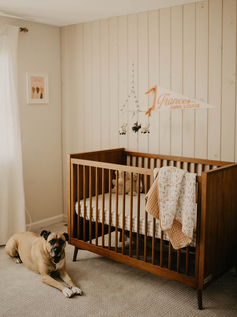 Far away view of crib with name banner on wall