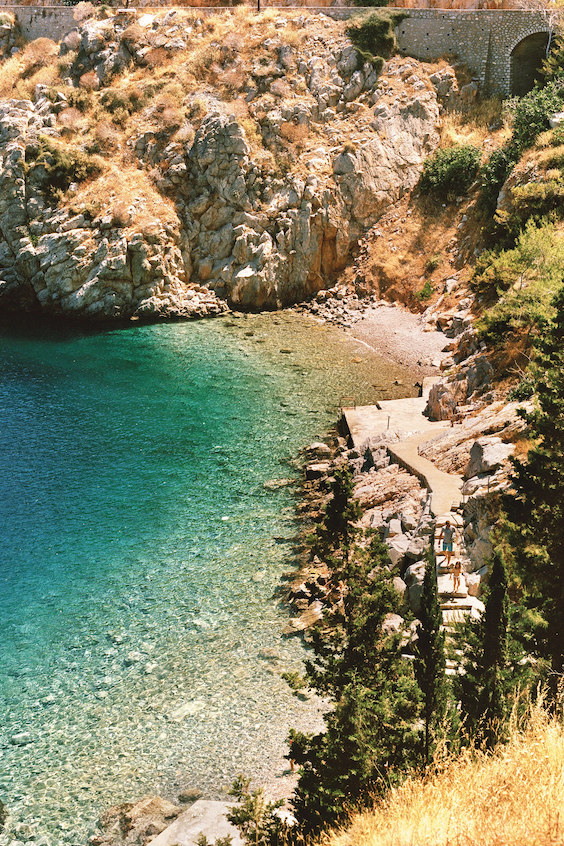 Crystal-clear water at a hidden beach between two rock creations in Hydra