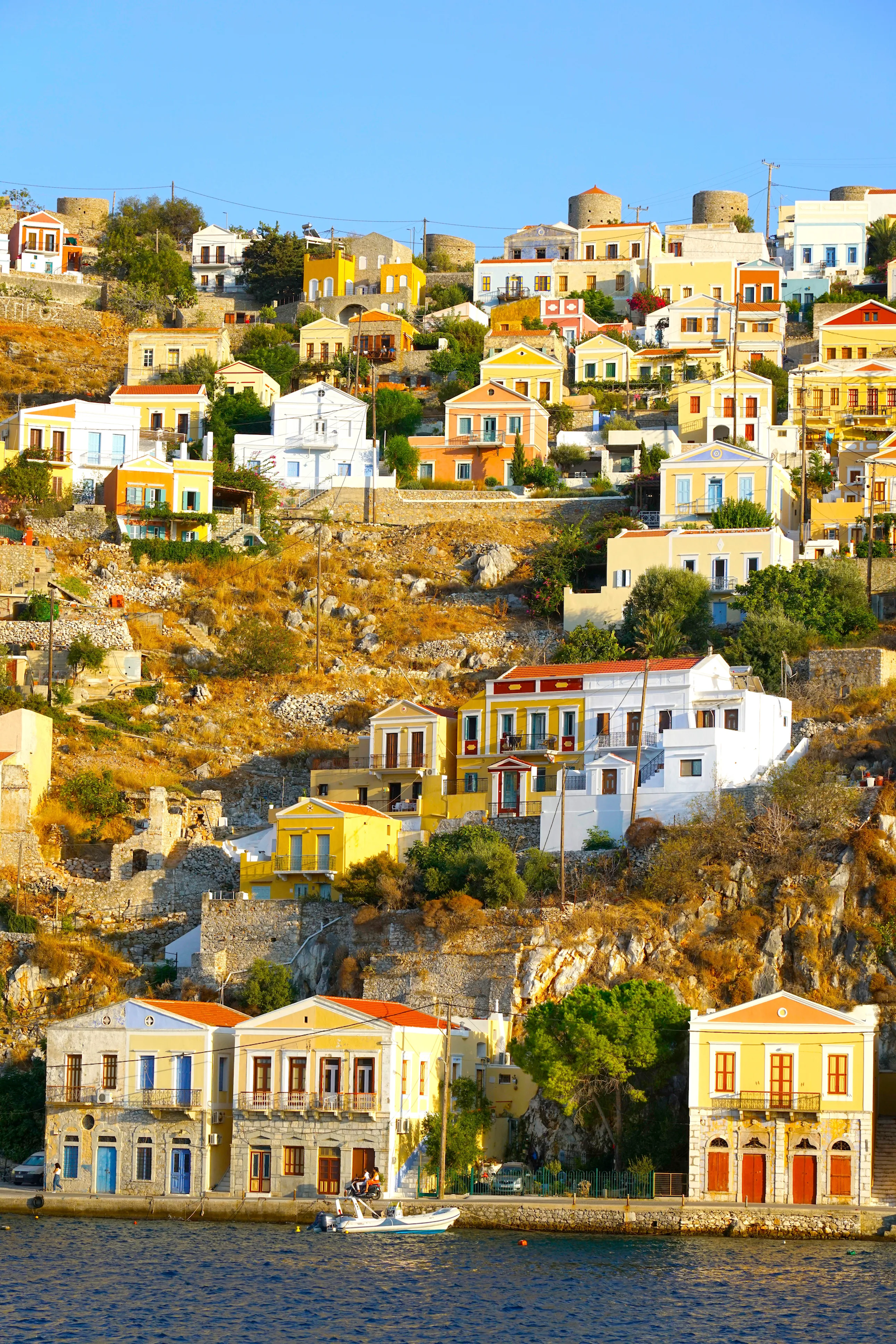 Rows of colorful neoclassical mansions that line the waterfront, creating a postcard-perfect scene in Symi