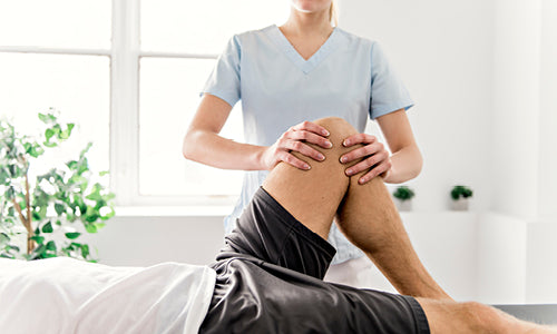 Doctor positioning patient's knee in bent position