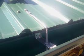 gutter hung from metal roofing using rod and nut hangers and cross bars