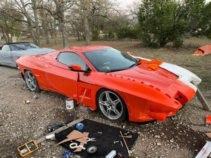 Un Corvette con motor central C8 rojo que se está convirtiendo con paneles de carrocería del Corvette C2.
