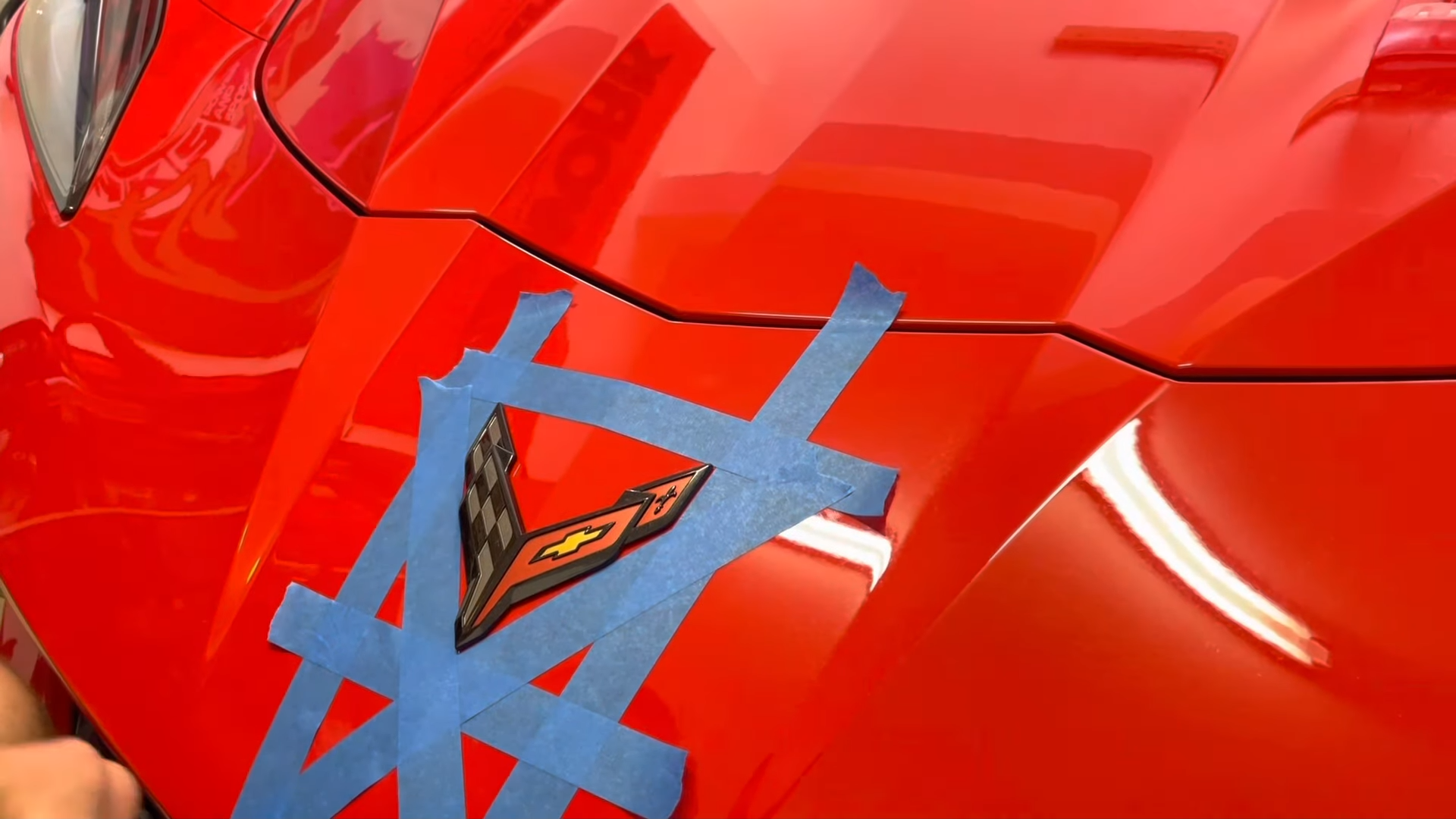 Applying masking tape around the c8 emblem