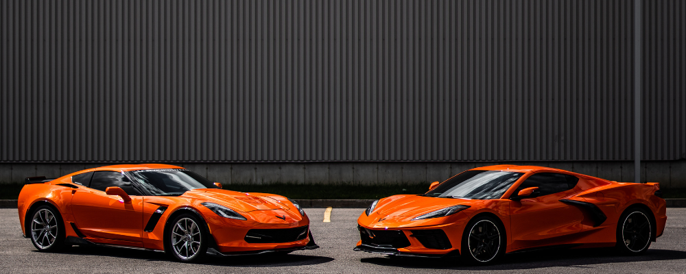 A C7 and C8 Corvette facing eachother both in Sebring Orange