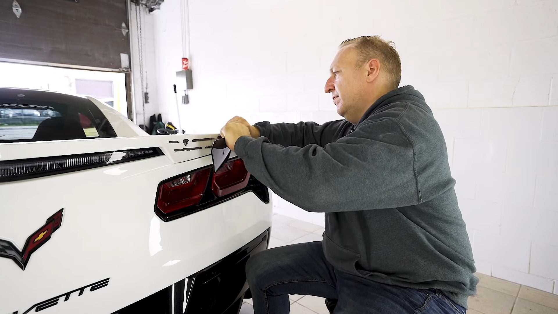 After removing the T30 screws, remove the wickers by consistently pulling it, as there is a two-way tape behind it, holding it to the spoiler.