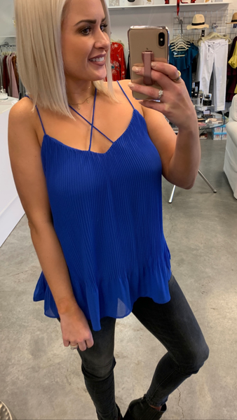 A women wearing a cobalt blue top with white jeans