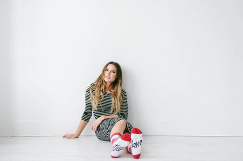 women in a stripped dress wearing true love socks