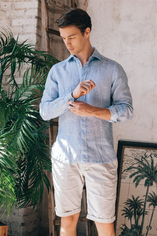 man wearing light blue linen shirt with beige shorts 