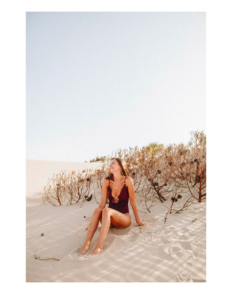 Woman sitting in the sand by the beach in Martha's Vineyard